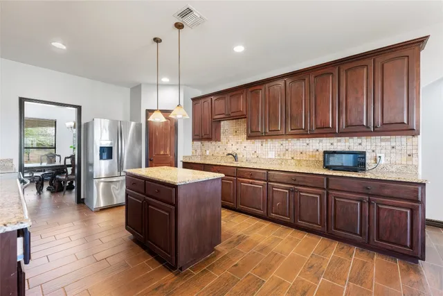 a kitchen with stainless steel appliances granite countertop wooden cabinets a stove top oven a sink and dishwasher