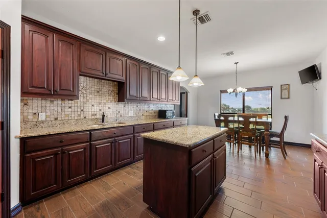 a kitchen with a table chairs sink and cabinets