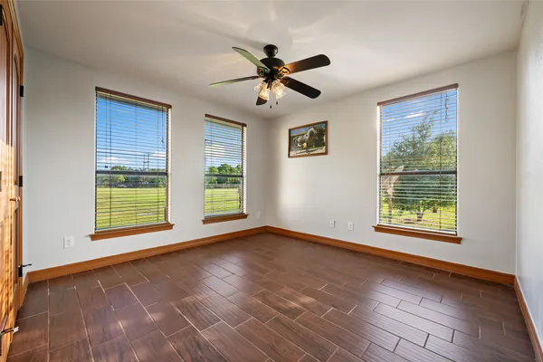a view of an empty room with a window and wooden floor