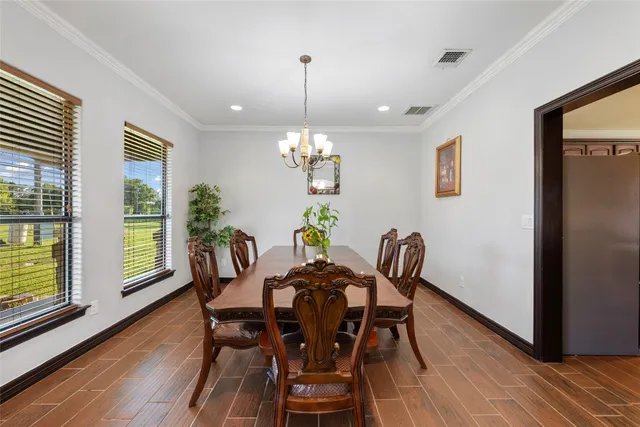 a dining room with furniture a chandelier and wooden floor