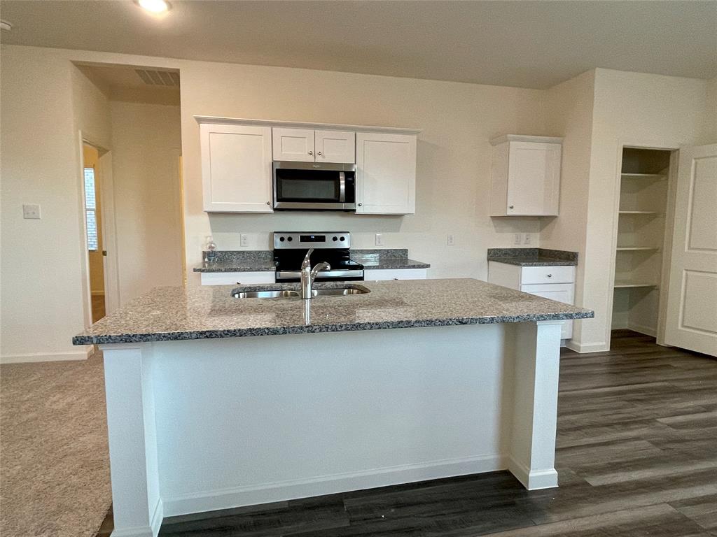 6222 Old Bridge Way Forney, TX 75126 - Photo 3 of 17 a kitchen with stainless steel appliances a sink a stove a microwave and cabinets