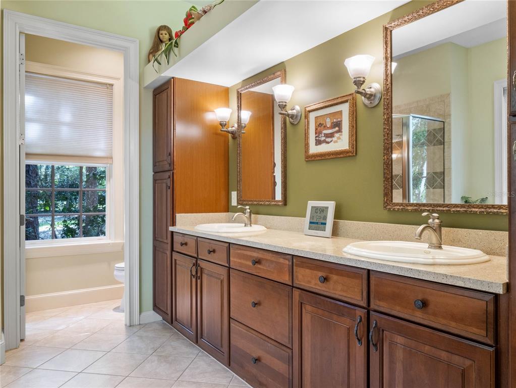 4000 Rouse Road Orlando, FL 32817 - Photo 14 of 53 a spacious bathroom with a double vanity sink a large mirror and a shower