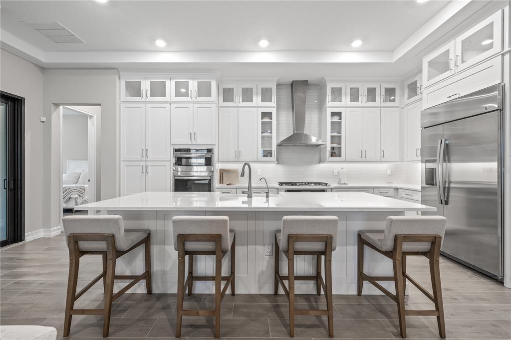 2632 Yellow Sundial Loop Ruskin, FL 33570 - Photo 15 of 52 a kitchen with stainless steel appliances granite countertop white cabinets and chairs
