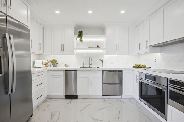 a kitchen with white cabinets stainless steel appliances and a sink