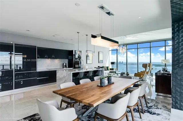 a kitchen with stainless steel appliances kitchen island granite countertop a table chairs and a view of living room