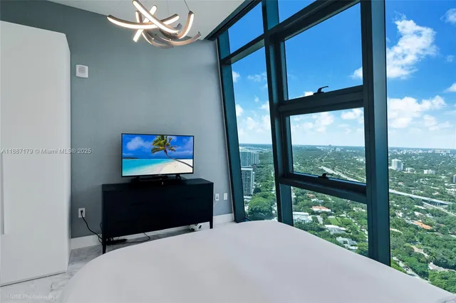 a bedroom with large window and a bed