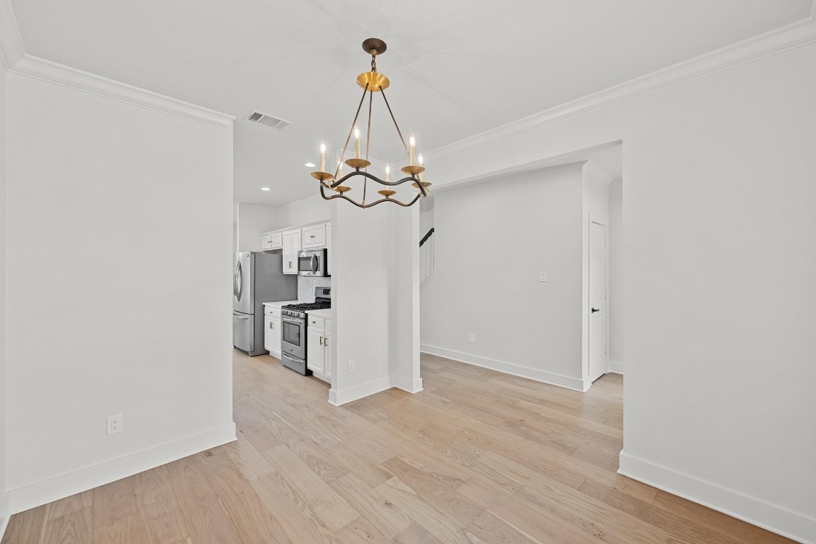 117 Waterloo Drive Kyle, TX 78640 - Photo 12 of 39 a view of a room with wooden floor staircase and a chandelier