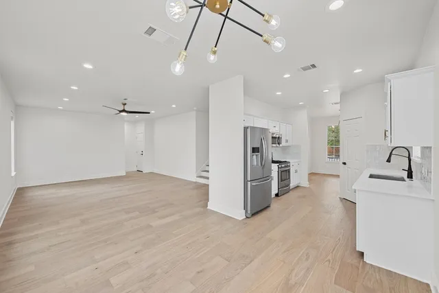 a view of a kitchen with a sink and a refrigerator