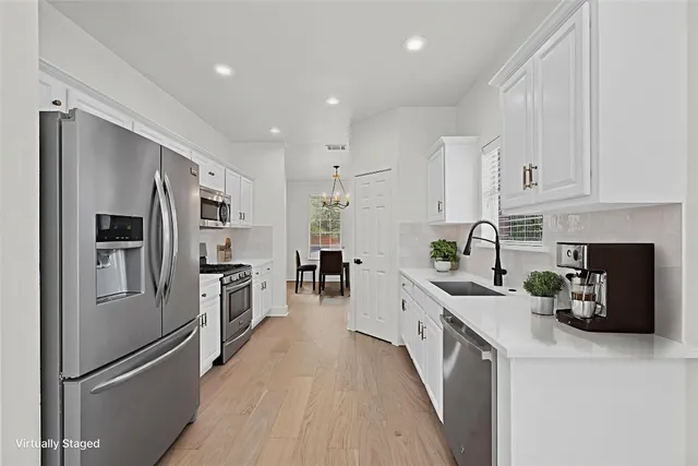 a kitchen with white cabinets and stainless steel appliances