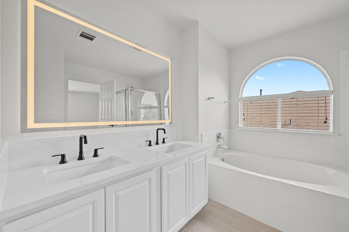 117 Waterloo Drive Kyle, TX 78640 - Photo 23 of 39 a bathroom with a tub a sink and a mirror