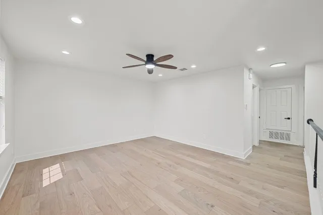 an empty room with a window and a ceiling fan
