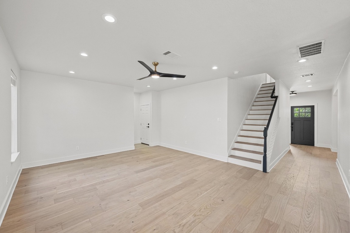 117 Waterloo Drive Kyle, TX 78640 - Photo 6 of 39 an empty room with a hallway and wooden floor