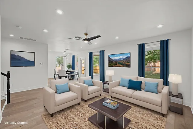 a living room with furniture and a ceiling fan