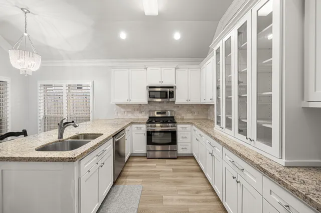 a kitchen with granite countertop a sink and steel appliances
