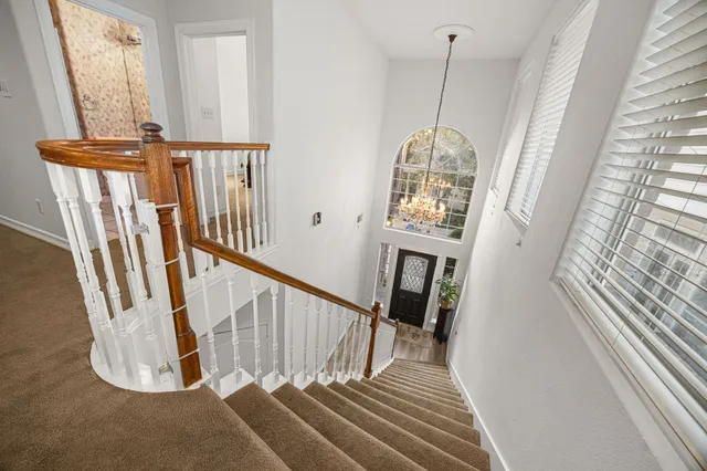 a view of a staircase with wooden floor and windows