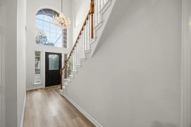a view of a hallway with wooden floor and staircase