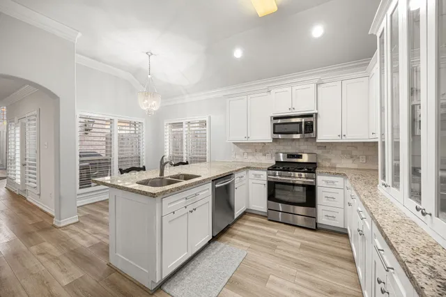 a kitchen with stainless steel appliances granite countertop a stove top oven a sink and dishwasher