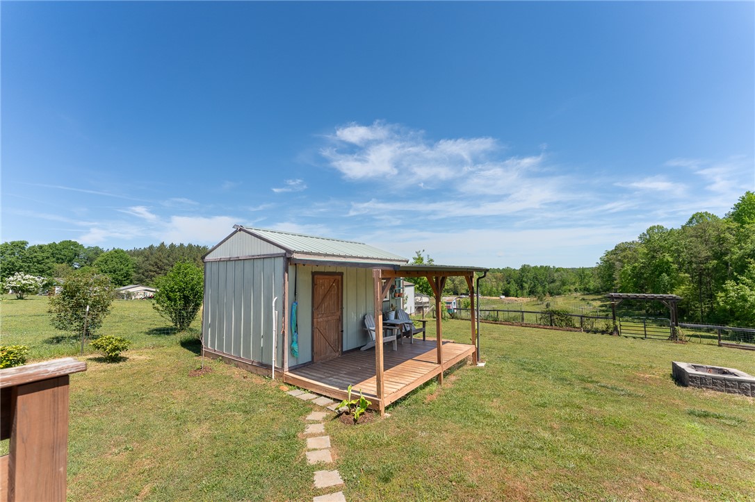 696 Mt Olivet Road Six Mile, SC 29682 - Photo 24 of 35 This quaint shed with an inviting porch offers a perfect blend of utility and outdoor enjoyment.