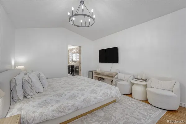 a spacious bedroom with a bed and a flat screen tv
