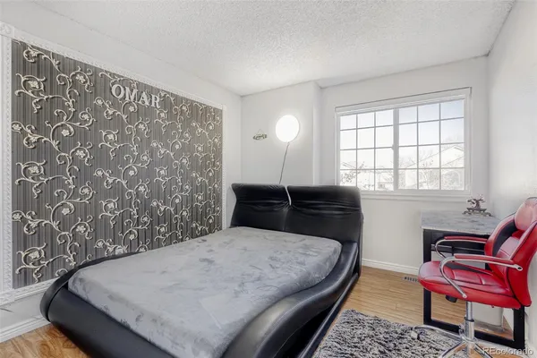 a bedroom with a bed and wooden floor