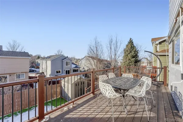 a view of a roof deck with table and chairs with wooden floor and fence