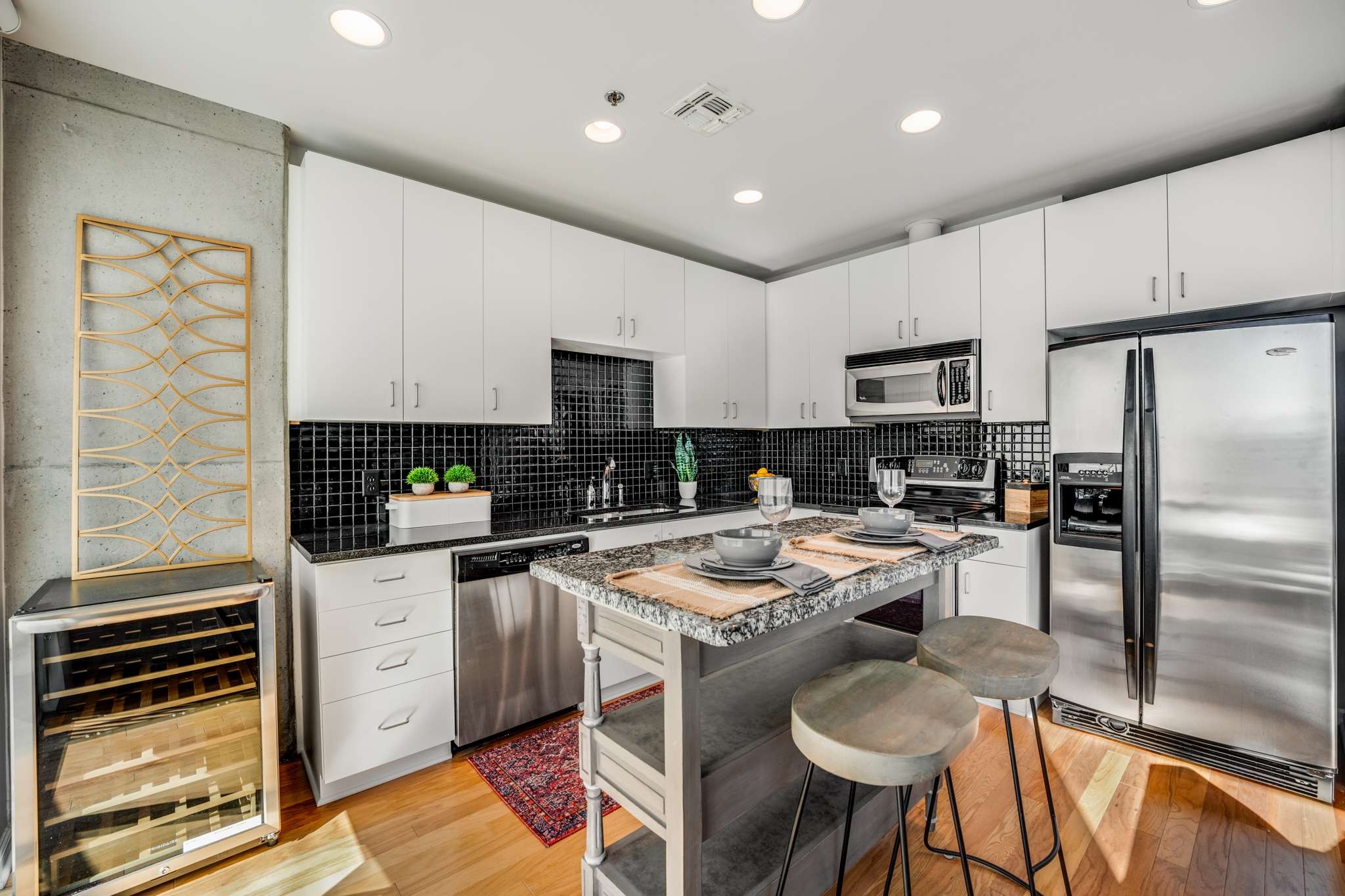 a kitchen with stainless steel appliances granite countertop a stove top oven a sink refrigerator and cabinets