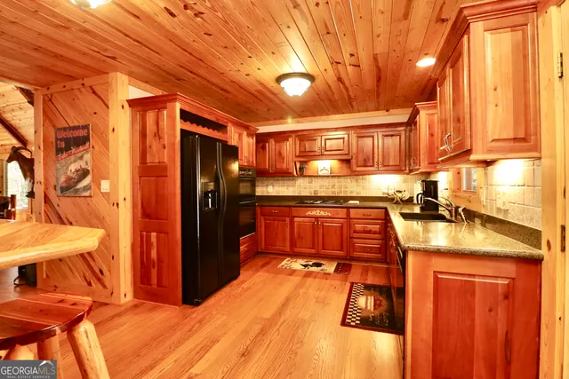 a kitchen with stainless steel appliances kitchen island granite countertop a refrigerator and a stove top oven