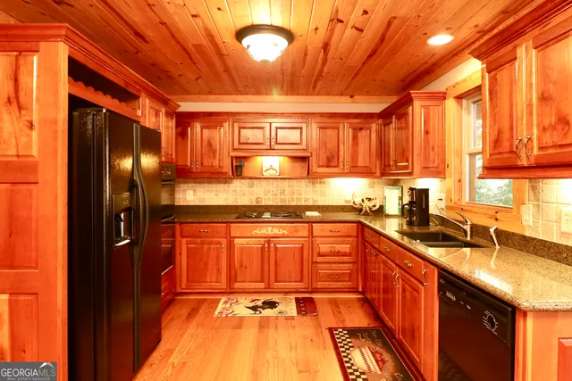 a kitchen with stainless steel appliances granite countertop a sink and cabinets