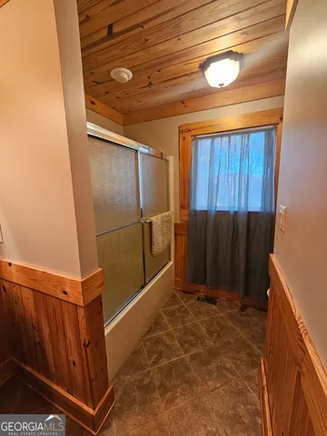 a view of hallway with wooden floor and chandelier