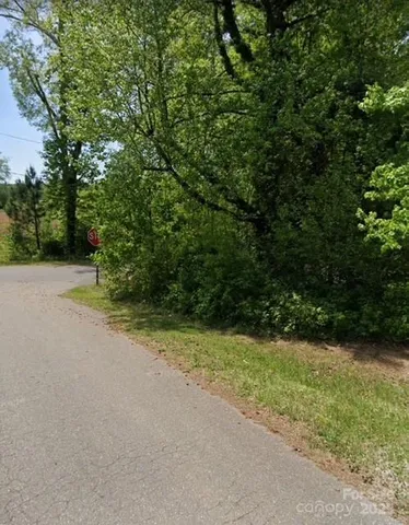 a view of a field with trees in background