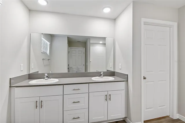 a bathroom with a granite countertop sink and a mirror