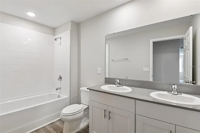 a bathroom with a double vanity sink toilet and a bathtub