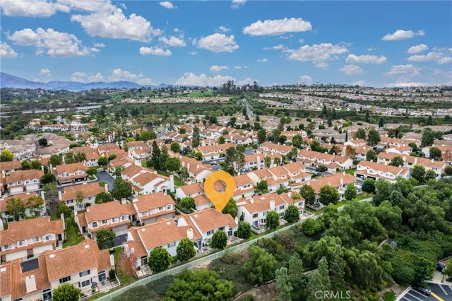 an aerial view of residential houses with outdoor space and trees