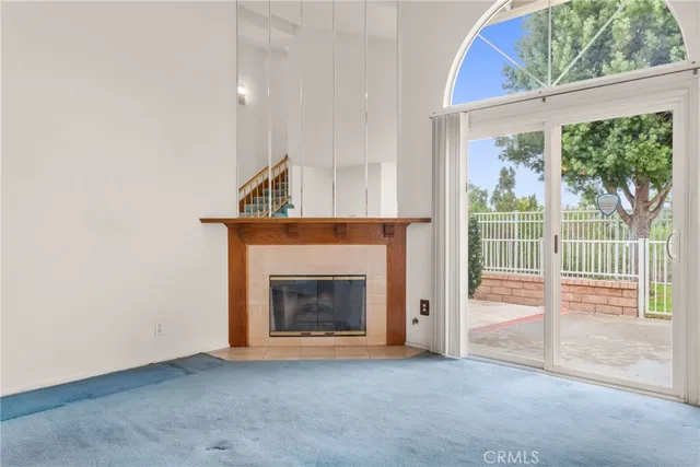 an empty room with fireplace and a window
