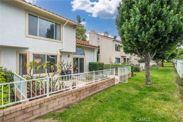 a view of an house with backyard and a tree