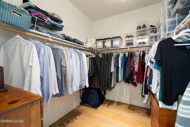a view of walk in closet with clothes and shoes