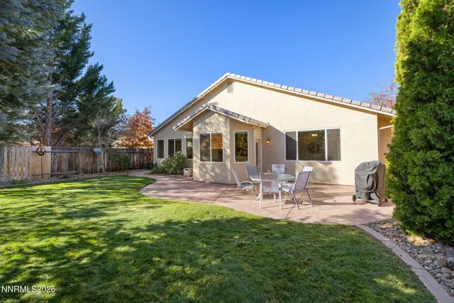 a view of a house with backyard and sitting area