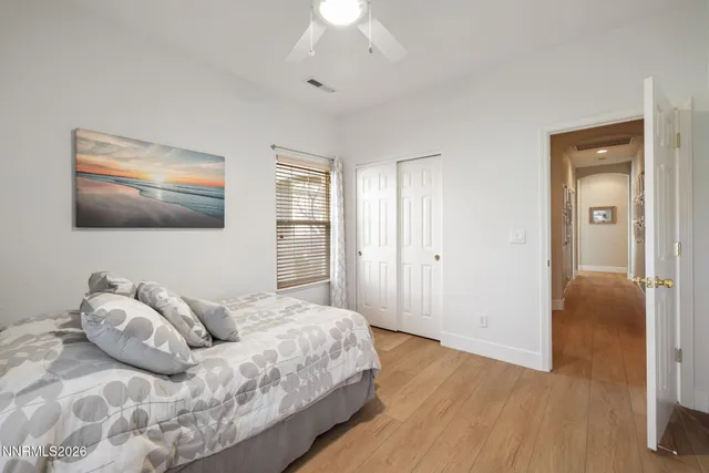 a spacious bedroom with a bed and a flat screen tv