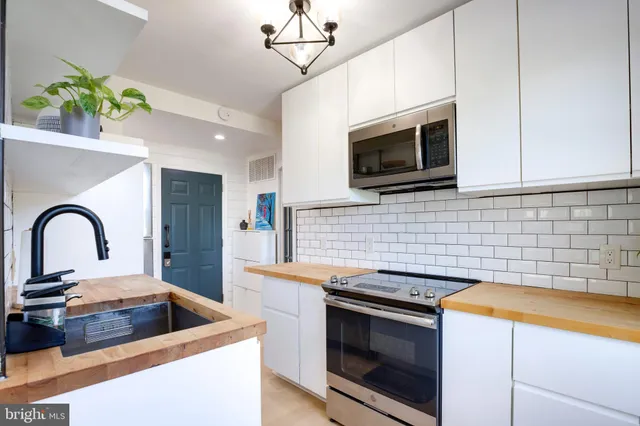 a kitchen with stainless steel appliances a stove a microwave sink and cabinets