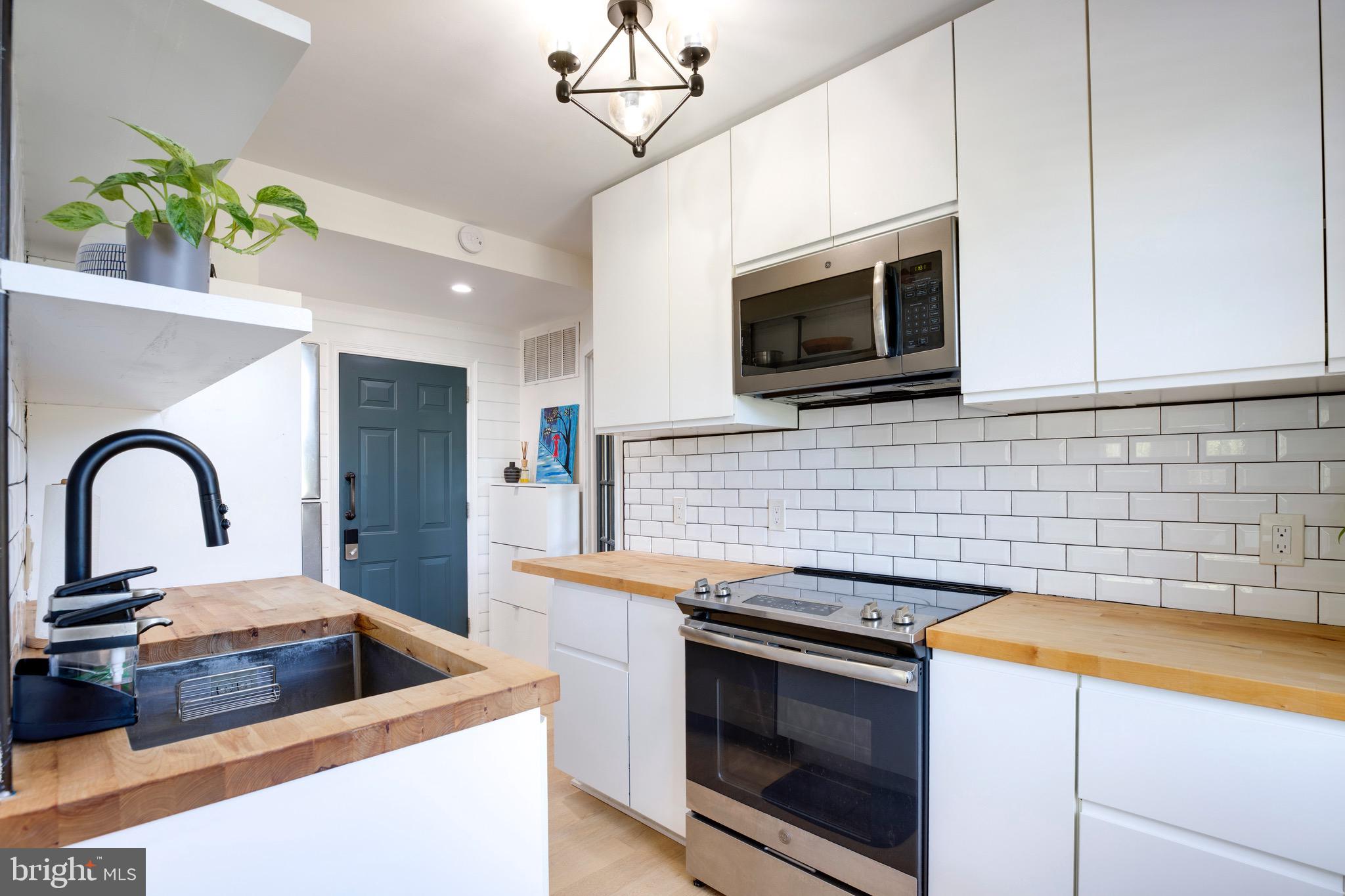 a kitchen with stainless steel appliances a stove a microwave sink and cabinets