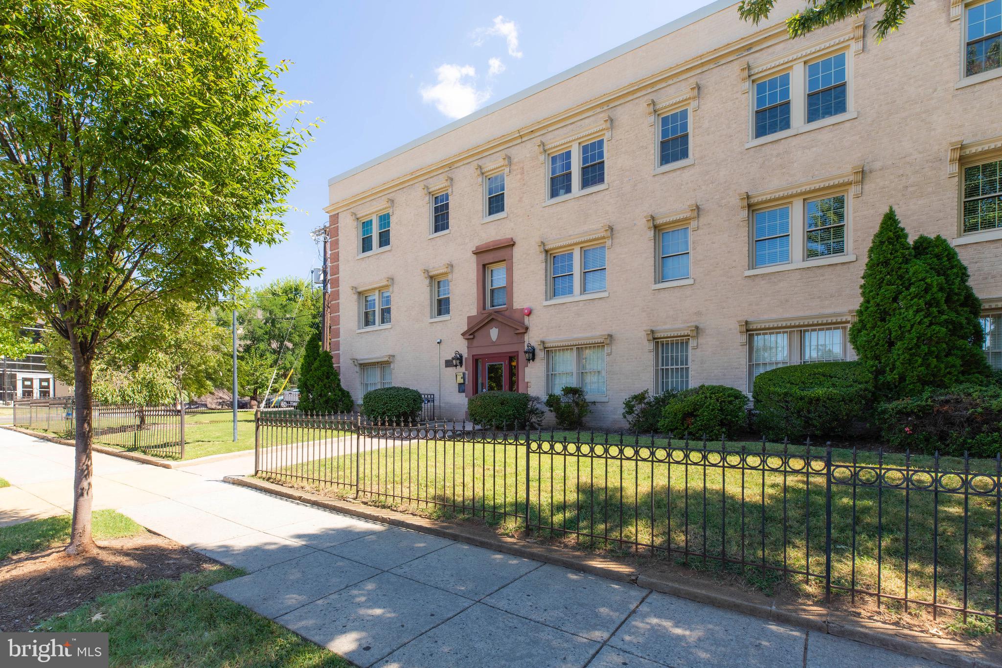 2625 3rd Street Northeast, Unit 203 Washington, DC 20002 - Photo 21 of 25 a view of a brick building next to a yard with large trees