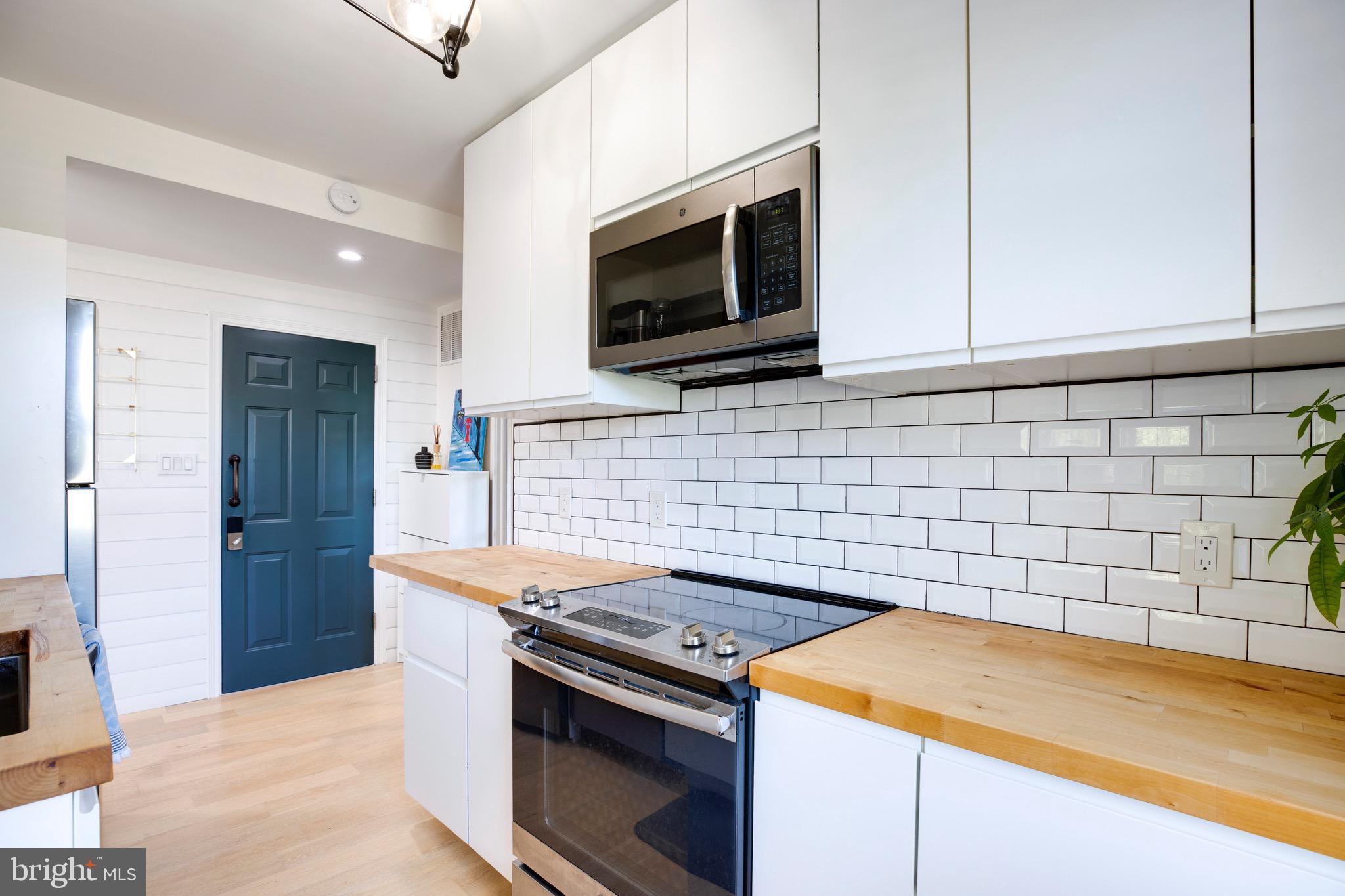 2625 3rd Street Northeast, Unit 203 Washington, DC 20002 - Photo 3 of 25 a kitchen with granite countertop cabinets stainless steel appliances and wooden floor