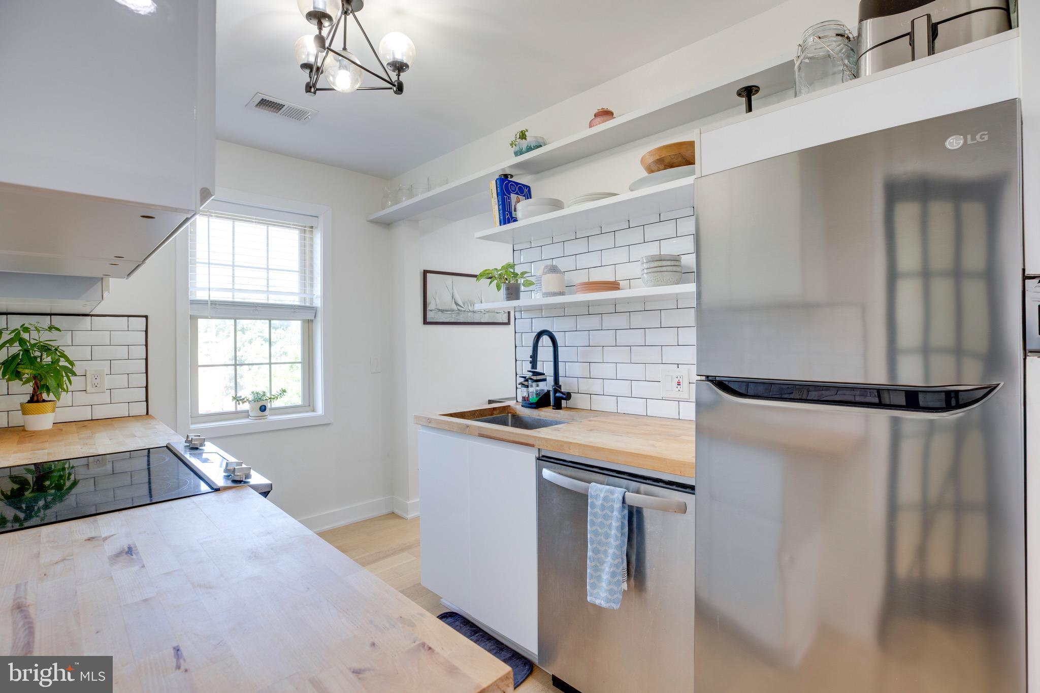 2625 3rd Street Northeast, Unit 203 Washington, DC 20002 - Photo 5 of 25 a kitchen with stainless steel appliances granite countertop a sink a refrigerator and a stove