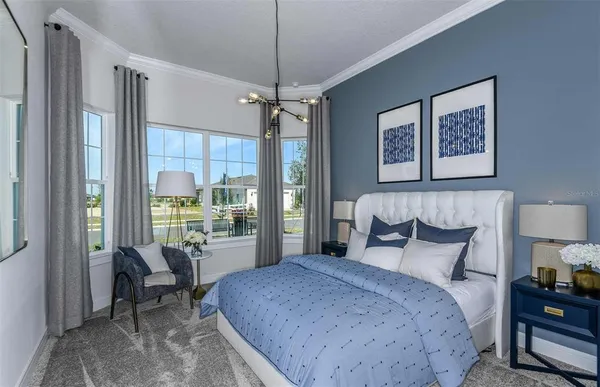 a bedroom with a bed painting on wall and a large window