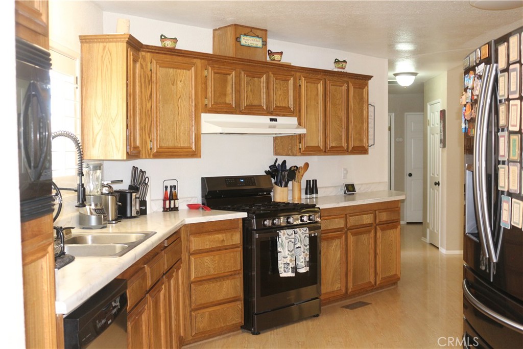 9453 Sharon Way Calimesa, CA 92320 - Photo 11 of 15 a kitchen with stainless steel appliances granite countertop a sink stove and refrigerator
