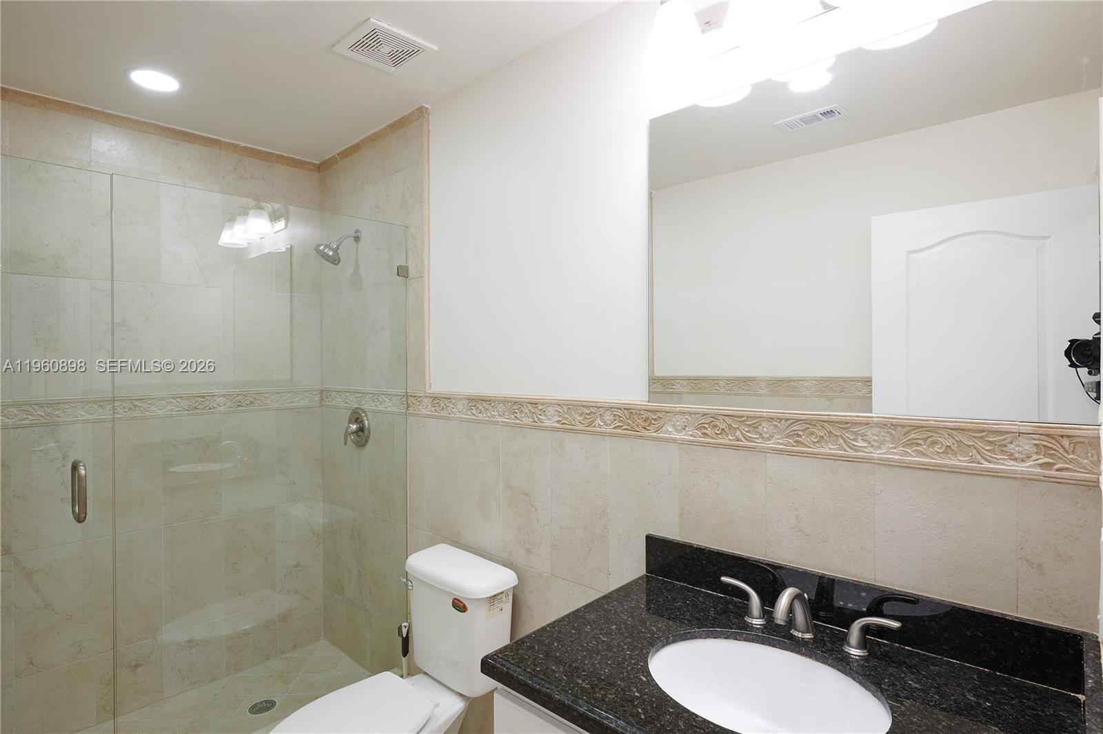 20030 Northwest 83rd Court Hialeah, FL 33015 - Photo 16 of 33 a bathroom with a granite countertop sink mirror vanity and toilet