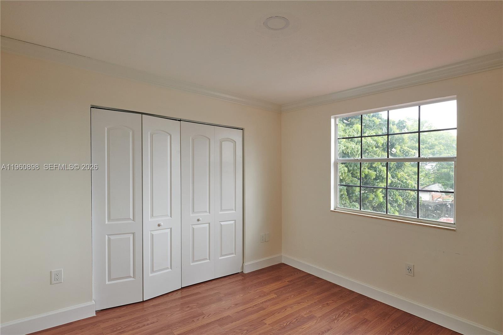 20030 Northwest 83rd Court Hialeah, FL 33015 - Photo 19 of 33 a view of an empty room with wooden floor and a window