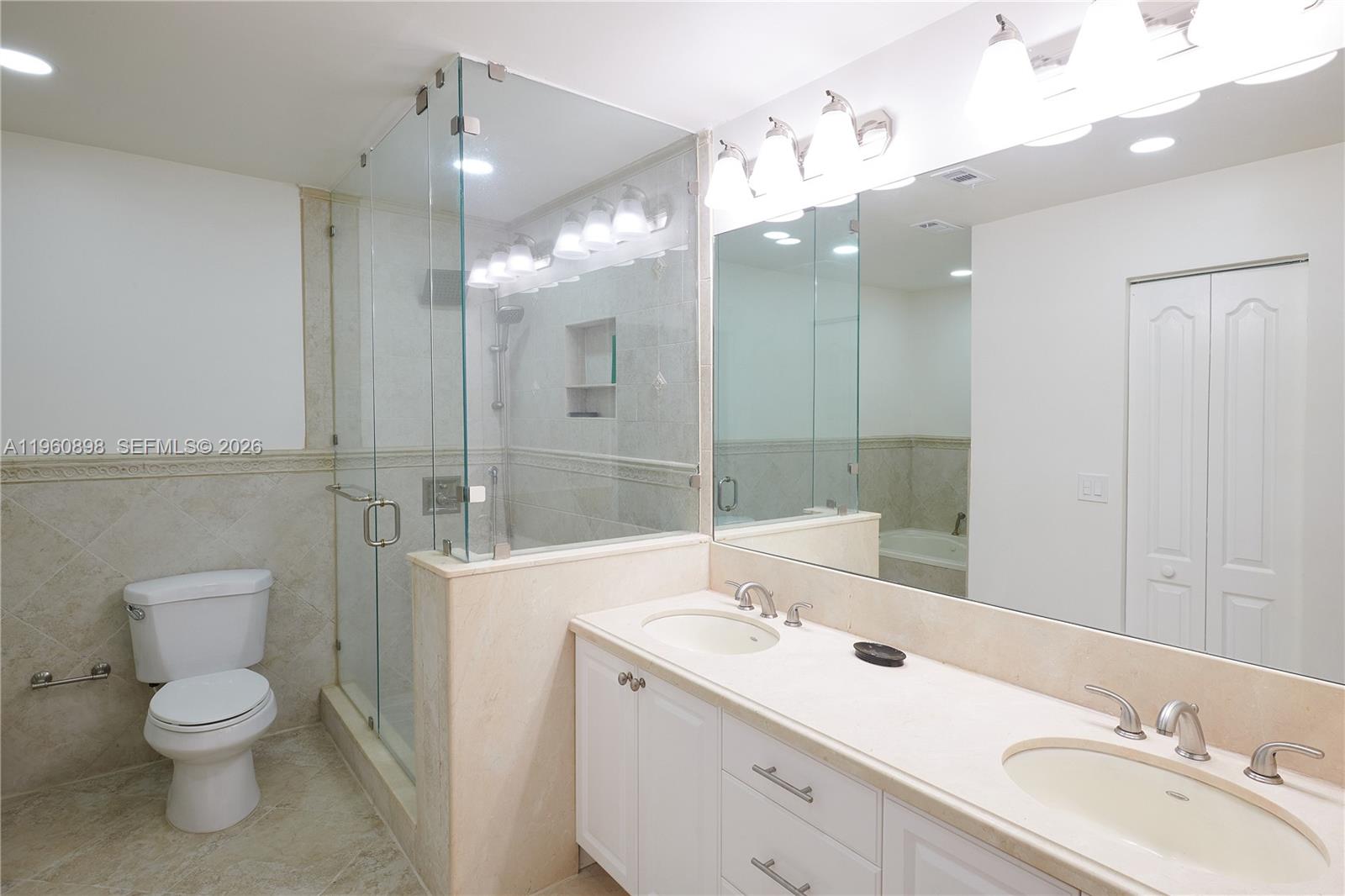 20030 Northwest 83rd Court Hialeah, FL 33015 - Photo 20 of 33 a bathroom with a toilet a sink a mirror a shower a vanity and window