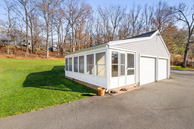 a view of a house with a yard and a large tree