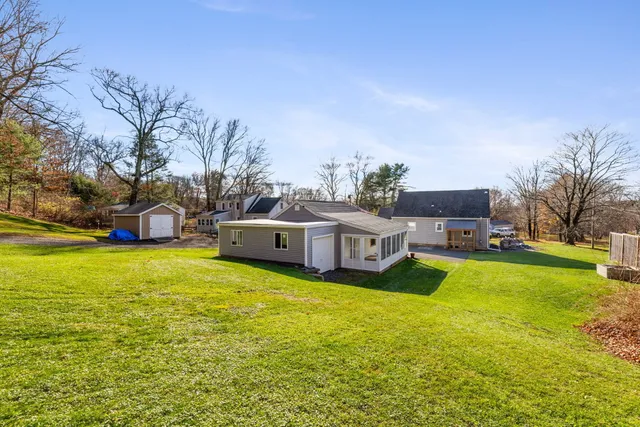 a view of a house with backyard and a tree